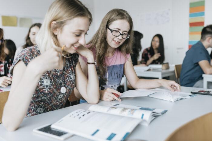 Sommerkurs in Aachen: Internationale Studierende sitzen gemeinsam in einem Klassenraum und nehmen aktiv an einem Deutschkurs für Studium und Beruf teil.
