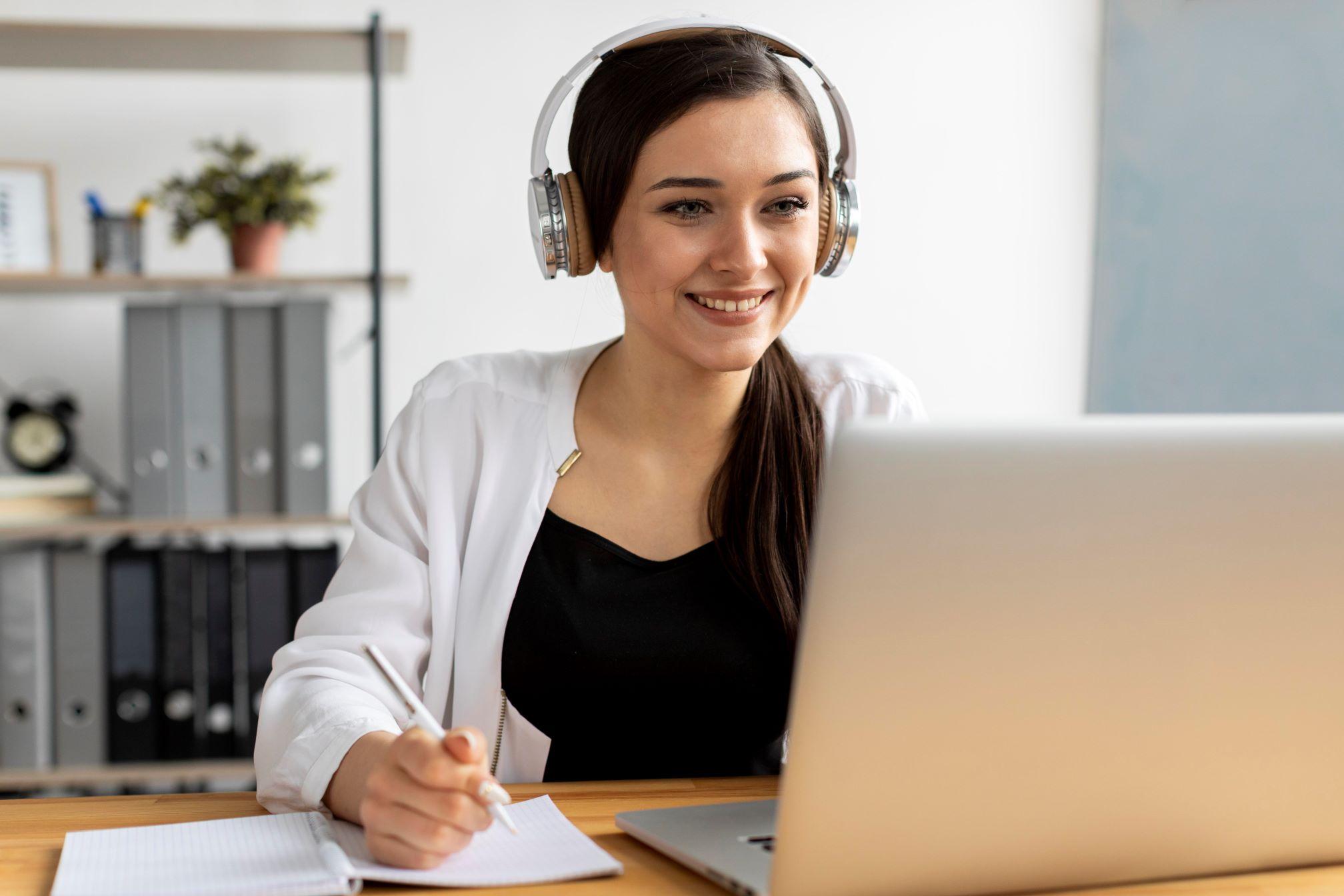 Deutsch als Fremdsprache lehren: Eine Deutschlehrerin sitzt vor ihrem Laptop und nimmt interessiert an der Online-Weiterbildung teil.