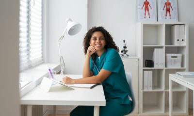 Online professional language course in German for healthcare professionals: A nurse in work clothes sits in front of the computer, ready to start the course.