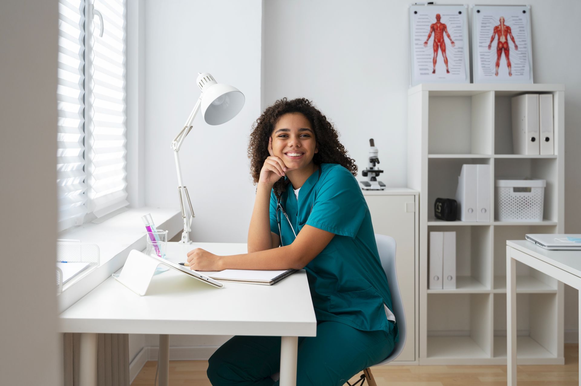 Online professional language course in German for healthcare professionals: A nurse in work clothes sits in front of the computer, ready to start the course.